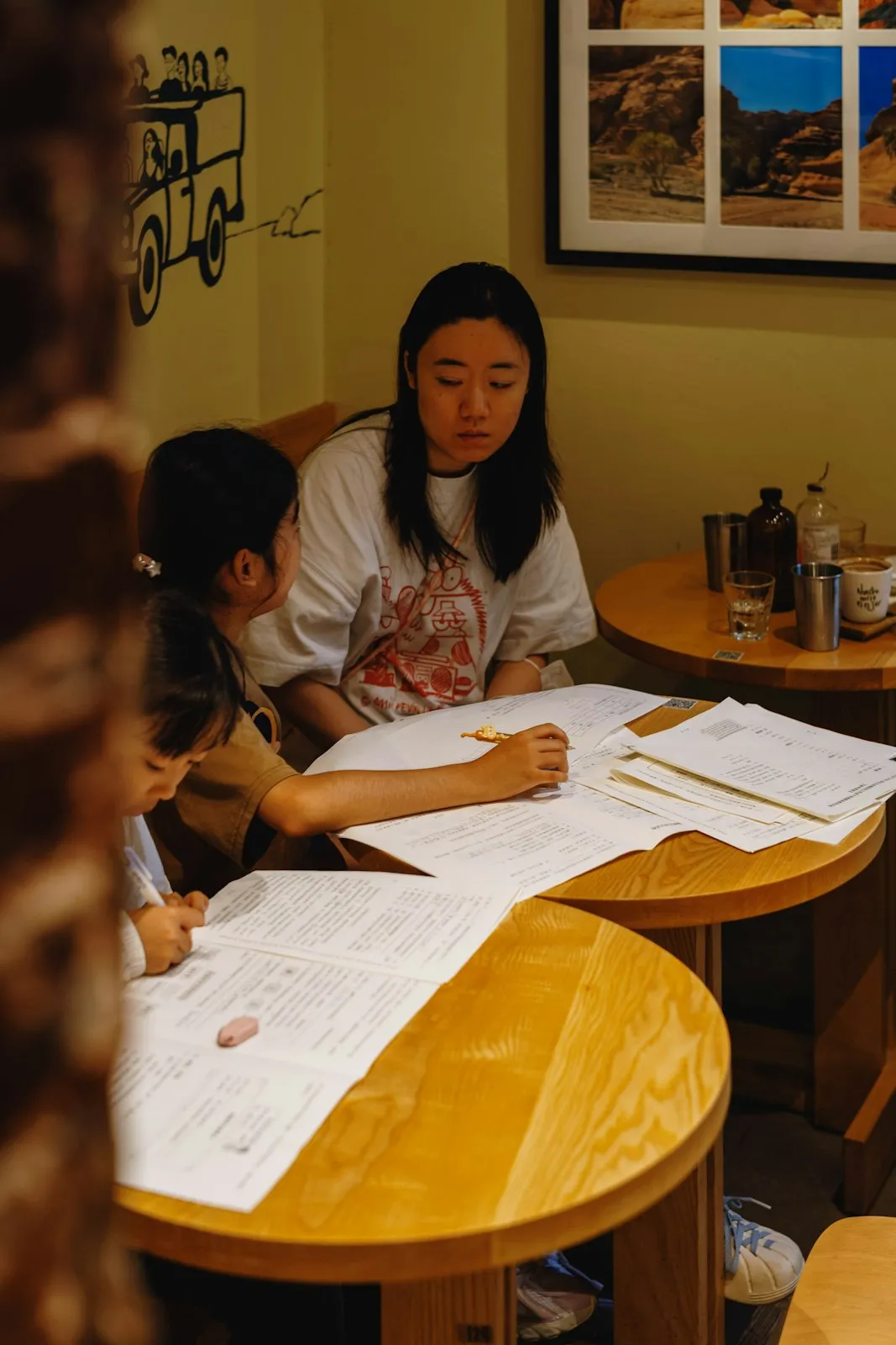 A tutor working through worksheets with a young student.